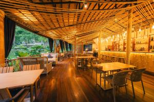 a restaurant with tables and chairs and a bar at La Lanna in Ban Pok Nai