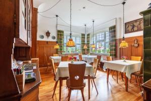 a dining room with white tables and chairs at Pension Alte Gerbe in Außerurberg