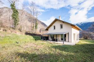 a small white house in the middle of a field at Maison jarrier ski , vélo in Saint-Jean-de-Maurienne