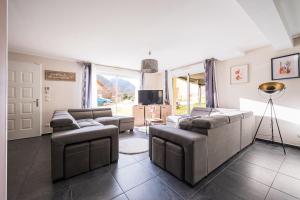 a living room with two couches and a television at Maison jarrier ski , vélo in Saint-Jean-de-Maurienne