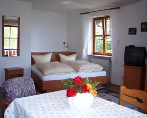 a bedroom with two beds and a table with a vase with flowers at Baumanns Ferienhof Am See in Bettnau