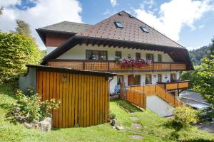 a large house with a wooden fence in front of it at Gästehaus Klingele in Todtmoos