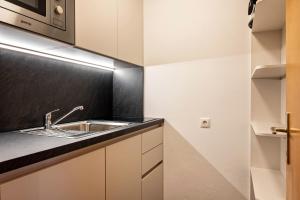 a kitchen with white cabinets and a sink at Appartement Schlern Living 1 in Völs am Schlern +12 photos