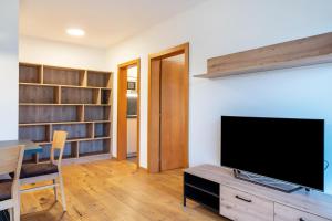a living room with a flat screen tv on a table at Appartement Schlern Living 1 in Völs am Schlern