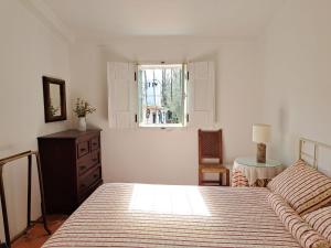 a bedroom with a bed and a dresser and a window at Monte Horta da Velhinha in Redondo