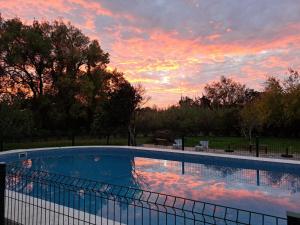 a large swimming pool with a sunset in the background at Monte Horta da Velhinha in Redondo