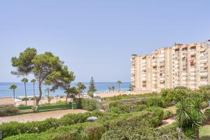 a large apartment building with the ocean in the background at Primera línea con terraza A104 in Torrox