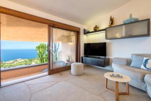 a living room with a couch and a large window at Villa Sirius - sea view - wellness in Costa Paradiso