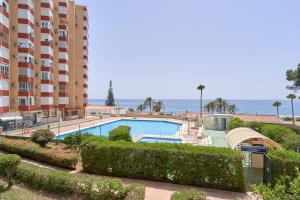 a swimming pool in front of a large building at Primera línea con terraza A104 in Torrox