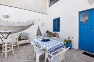 a patio with a table and chairs and a blue door at Casa dos Afectos - Costa Nova in Gafanha da Encarnação