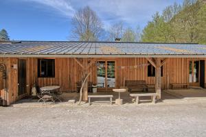 a wooden cabin with a bench and a table at Maison Skioura, Gite De Groupe in Luchon