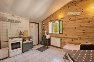 a kitchen with wooden walls and a stove top oven at Maison Skioura, Gite De Groupe in Luchon