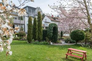 a red bench in the yard of a house at Ferienwohnung Kunstmann in Überlingen