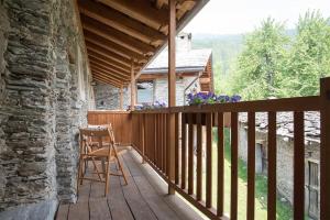 a wooden balcony with a wooden chair on a house at Civico 6 in Marmora
