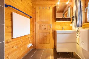 a small kitchen with wooden walls and a door at Hütte im Heidekreis in Lindwedel
