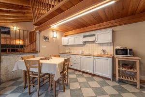 a kitchen with white cabinets and a table and chairs at Civico 6 in Marmora