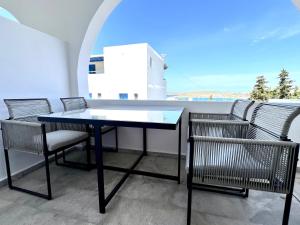 a table and chairs on a balcony with a view at aeolian blu 6 in Parikia
