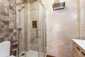 a shower with a glass door in a bathroom at Entre Eras Aptos Rurales La Bodega in Ademuz