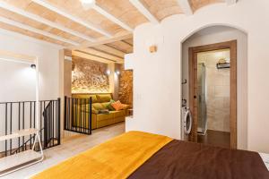 a bedroom with a bed and a living room at Entre Eras Aptos Rurales La Bodega in Ademuz