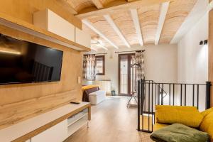 a living room with a large flat screen tv on a wall at Entre Eras Aptos Rurales La Bodega in Ademuz