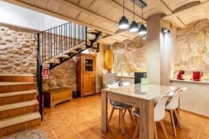 a dining room with a table and a staircase at Entre Eras Aptos Rurales La Bodega in Ademuz