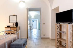 a living room with a flat screen tv and a bed at Arco Antelmy in Ceglie Messapica