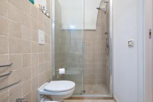 a bathroom with a toilet and a glass shower at Arco Antelmy in Ceglie Messapica +14 photos