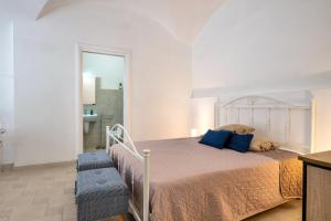 a bedroom with a bed with blue pillows at Arco Antelmy in Ceglie Messapica