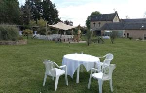 a white table and chairs in a yard at Domaine de Meslay in Fyé