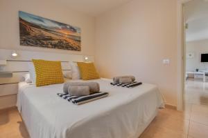 a large white bed with towels on top of it at Oasis Duna_ Casa Elena Pool in Corralejo +25 photos