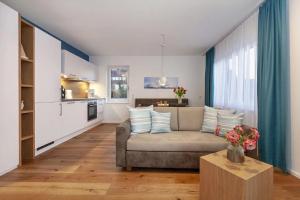 a living room with a couch and a kitchen at Appartements Bank Am See in Immenstaad am Bodensee +30 photos
