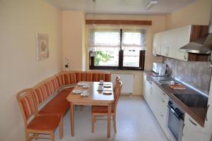 a kitchen with a wooden table and chairs and a table and a tablektop at Ferienwohnung Dürnbach in Albstadt