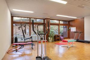 a gym with several exercise equipment in a room at Schwarzwaldliebe mit Pool, Sauna in Schönwald