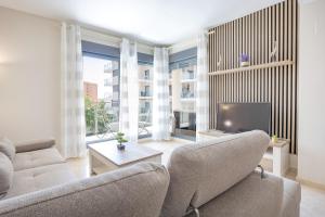 a living room with two couches and a tv at Cala alta in Benidorm
