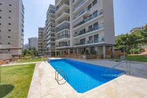 an apartment with a swimming pool in front of a building at Cala alta in Benidorm