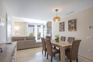 a dining room and living room with a table and chairs at Cala alta in Benidorm