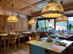 a restaurant with tables and chairs and chandeliers at Pension Linde in Höchenschwand +31 photos