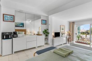 a white room with a bed and a kitchen at Miraflores A112 in La Cala de Mijas
