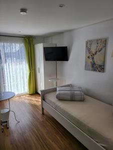 a bedroom with a bed and a flat screen tv at Pension Linde in Höchenschwand