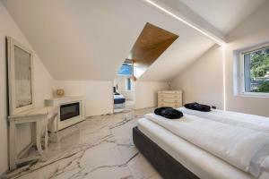 a large white room with two beds and a fireplace at App 301 Palazzo Cavour in Bolzano