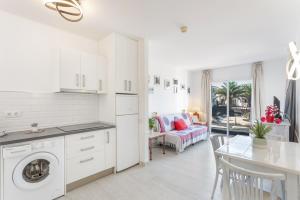 a white kitchen with a table and a dining room at Relax Holidays Corralejo in Corralejo
