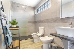 a bathroom with a toilet and a sink at Relax Holidays Corralejo in Corralejo +27 photos