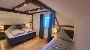 ein Schlafzimmer mit zwei Betten und einem Fenster in der Unterkunft Hümmer Chalets in Breitengüßbach