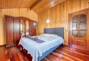 a bed in a room with wooden walls and wooden floors at Costacabana - Villa Primadonna in Lloret de Mar