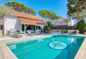 a swimming pool with chairs and a house at Costacabana - Villa Primadonna in Lloret de Mar