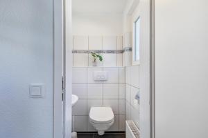 a small bathroom with a toilet and a sink at Pr-Ferienwohnung in Stierstadt +20 photos