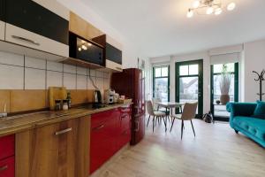 a kitchen with red cabinets and a blue couch at Gemütliche Wohnung in Reimsbach in Beckingen