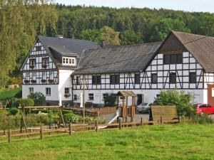 two white and black houses with a car parked in front at Ferienhof Schade in Eslohe