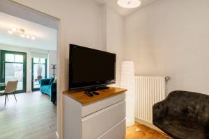 a living room with a flat screen tv on a dresser at Gemütliche Wohnung in Reimsbach in Beckingen