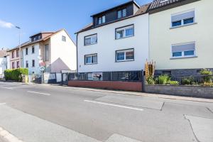an empty street in front of a white building at Pr-Ferienwohnung in Stierstadt